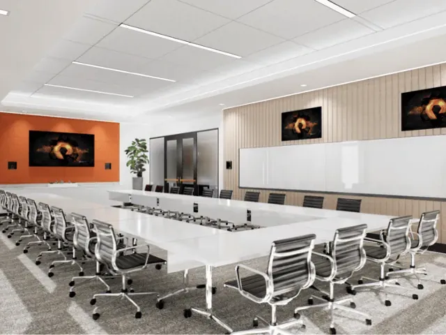 Large conference room with a long white table and screens